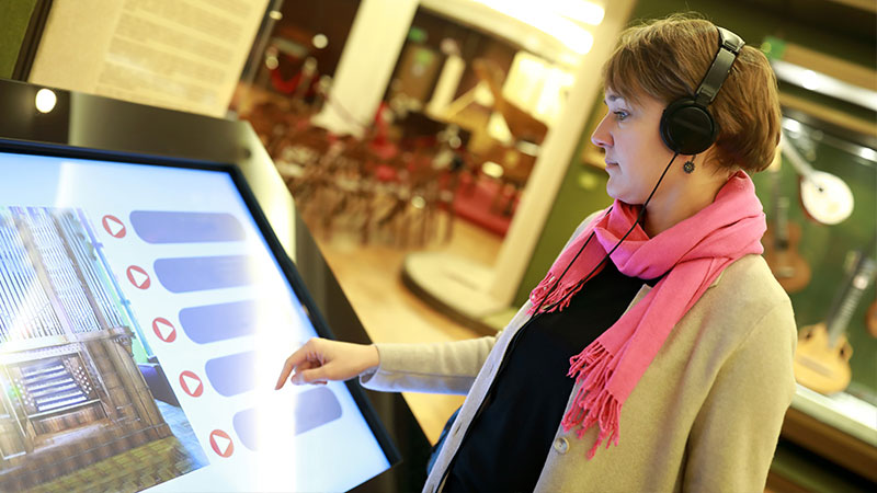 一名女子在百貨商場使用IP65觸控螢幕尋找樓層資訊