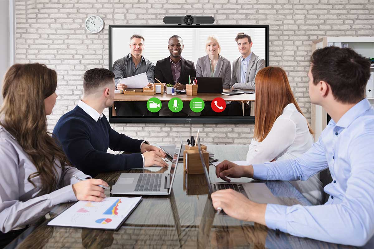A group of people are holding a video conference on Meetboard IFP-8602 interactive display in a huddle room