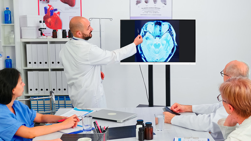 一名醫生在診間使用診斷醫療顯示器討論病患的X光片